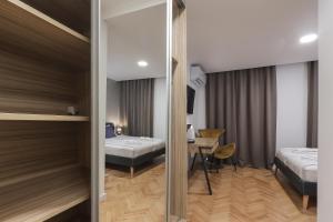 a bedroom with two beds and a desk in a room at Residence INN Rijeka in Rijeka