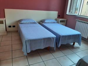 um quarto com duas camas com lençóis azuis em San Quirico Locanda ristorante pizzeria em Barbarasco