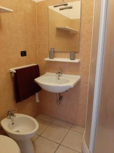 La salle de bains est pourvue d'un lavabo et de toilettes. dans l'établissement San Quirico Locanda ristorante pizzeria, à Barbarasco