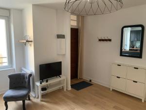 ein Wohnzimmer mit einem Stuhl und einem TV in der Unterkunft Appartement en plein cœur de Brest in Brest