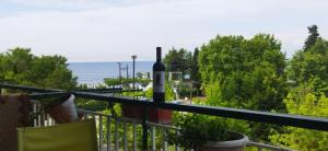 a bottle of wine on the balcony of a house at Irina Διαμέρισμα in Pálioura