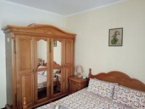 a bedroom with a wooden bed and a wooden cabinet at Centar Starog Grada in Kotor