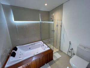 uma casa de banho com uma banheira, um chuveiro e um WC. em Casa dos Neves Suíte Master em Campos de Jordão mais 11 fotografias