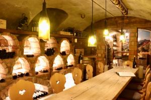 a room with a wooden table and lots of wine barrels at Hotel Lenzerhorn in Lenzerheide