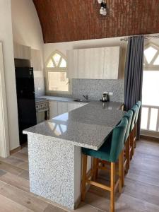 a kitchen with a counter and a island with chairs at Azzurra two-bedrooms apartment at Sahl Hasheesh in Hurghada