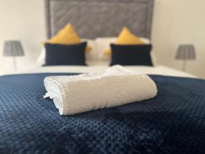 eine Rolle Toilettenpapier auf einem Bett in der Unterkunft Kingsway House - Spacious 4 Bed Home From Home in Derby in Derby