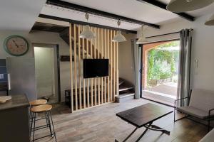a living room with a tv and a large window at La Maison du Bonheur in Six-Fours-les-Plages