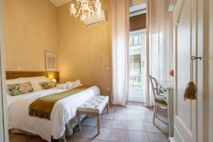 a bedroom with a bed and a table and a chandelier at xenìa in Syracuse