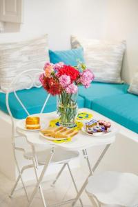 un tavolo bianco con un vaso di fiori sopra di The Bay - Loft apartment Sea & Sunset View a Oia