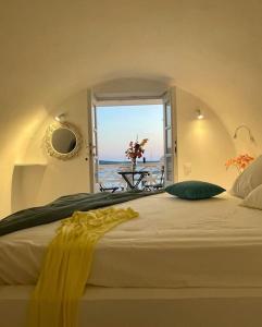 a bedroom with a bed with a view of the ocean at The Bay - Loft apartment Sea & Sunset View in Oia