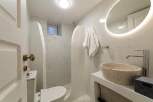 bagno bianco con lavandino e specchio di The Bay - Loft apartment Sea & Sunset View a Oia