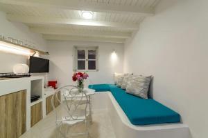 The Bay - Loft apartment Sea & Sunset View في أويا: غرفة معيشة مع أريكة وطاولة