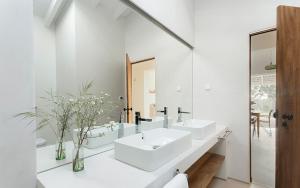 a white bathroom with two sinks and a mirror at Amaria in Aljezur