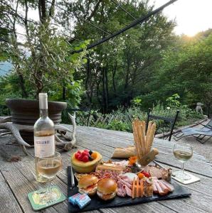 una mesa con un plato de comida y una botella de vino en Gite du Prinas, en Gréolières