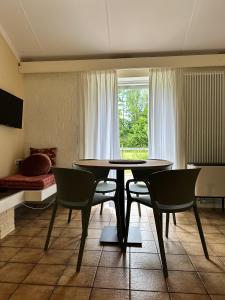 een woonkamer met een tafel en stoelen en een bed bij Achterhoekhuisje De Rode Beuk in Hummelo