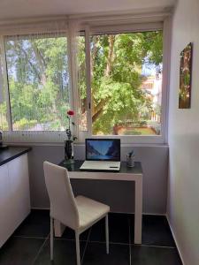 a desk with a laptop and a chair in front of a window at Cigalou 2km Marina Olympique - Parking gratuit in Marseille