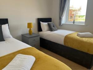 Kingsway House - Brand New Spacious 4 Bed Home From Home في ديربي: غرفة نوم بسريرين ونافذة