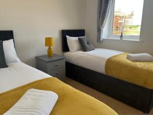 a bedroom with two beds and a window at Kingsway House - Spacious 4 Bed Home From Home in Derby in Derby