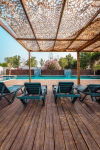 a deck with two chairs and a table and a pool at Camping le Roucan West in Vias