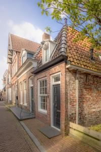 een rij stenen huizen op een straat bij Gasthuis Dokkum in Dokkum