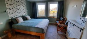 Dormitorio pequeño con cama y lavamanos en B&B de Zilverreiger, en Belt-Schutsloot