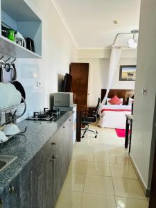 une chambre avec une cuisine et une chambre avec un lit dans l'établissement Mashpark Apartments, à Nairobi