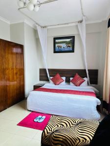 - une chambre avec un grand lit blanc et une couverture zébrée dans l'établissement Mashpark Apartments, à Nairobi