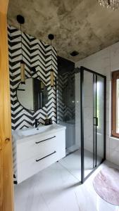 ein Bad mit einem Waschbecken und einem Spiegel in der Unterkunft DOMEK NA GÓRACH z JACUZZI I SAUNĄ in Nowy Sącz