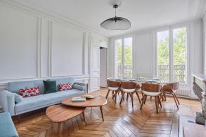 a living room with a couch and a table and chairs at Residence Le Marais by Studio prestige in Paris