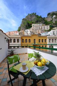 a table with a bowl of fruit on a balcony at MeFra Camere - Amalfi Coast in Atrani