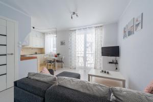 a living room with a couch and a kitchen at Apartament z balkonem przy Latarni 150m od morza in Kołobrzeg