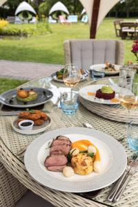 Stirrups Hotel في براكنيل: طاولة مع أطباق من الطعام وكؤوس من النبيذ