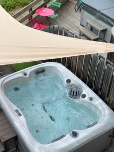a jacuzzi tub in a backyard with a deck at Hôtel Panorama in Munster