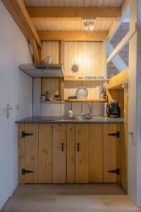 een keuken met houten kasten en een wastafel bij Gasthuis Dokkum in Dokkum