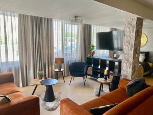 a living room with a couch and a tv at Glücklich am Meer Suite Deluxe mit Wellnesszugang in Egmond aan Zee