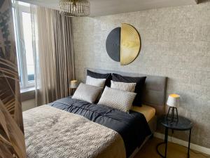 1 dormitorio con cama y espejo en la pared en Glücklich am Meer Suite Deluxe mit Wellnesszugang en Egmond aan Zee