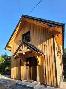 a large wooden building with a large door at DOMEK NA GÓRACH z JACUZZI I SAUNĄ in Nowy Sącz