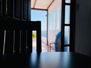 a table and a chair with a view of the ocean at Maya Mallis in Adamantas