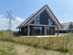 ein Haus mit schwarzem Dach und Fenstern in der Unterkunft Zandbank Villa's in Vrouwenpolder
