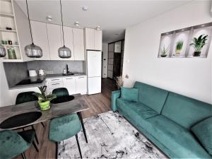 sala de estar con sofá verde y mesa en Aurea apartment en Vilna