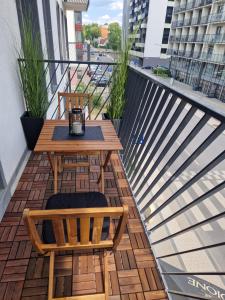 a balcony with a wooden table and two chairs at Aurea apartment in Vilnius