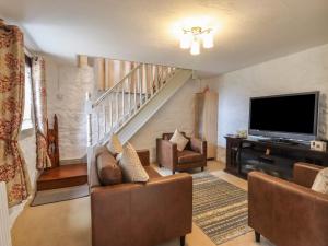 a living room with couches and a flat screen tv at The Old Hall in Holywell