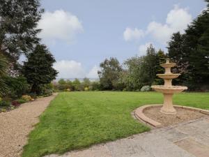 a park with a fountain in the middle of a field at The Old Hall in Holywell
