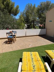 een patio met een tafel en een gele bank bij Chambre double cassis in Cassis