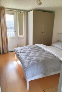 ein Schlafzimmer mit einem weißen Bett und einem Fenster in der Unterkunft Silver Lotus in De Haan