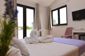 una habitación de hotel con dos toallas de cisne en una cama en Gargamelo Pension, en Poreč