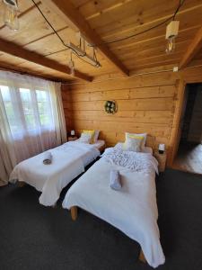 sypialnia z 2 łóżkami w drewnianym domku w obiekcie Apartament Zakątek Góralki w Zakopanem