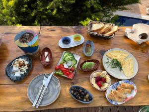 a wooden table with plates of food on it at Deep Ocean Camping-Adults Only in Faralya +30 photos