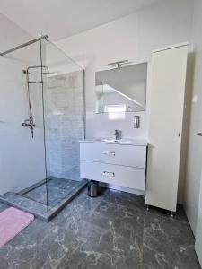 a bathroom with a glass shower and a sink at Villa AISHA with private jacuzzi in Novalja +31 photos