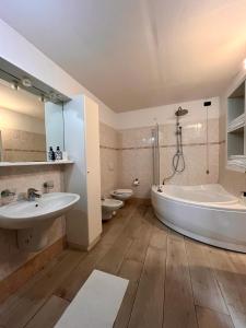 a bathroom with a tub and a sink and a toilet at Case vacanza le vele in Desenzano del Garda